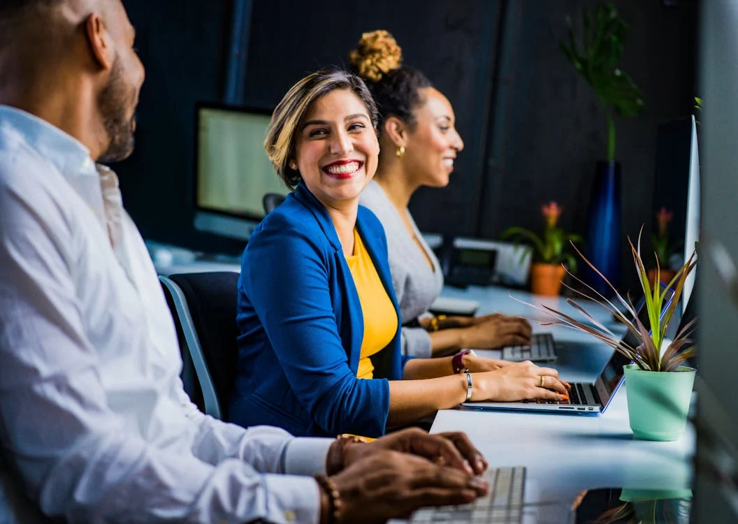 Grupo de pessoas sorrindo no escritório e no ambiente de trabalho
