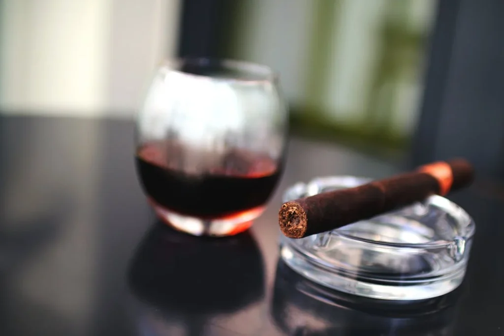 Charuto e bebida sobre mesa, destacando o mercado desses produtos em Cuba